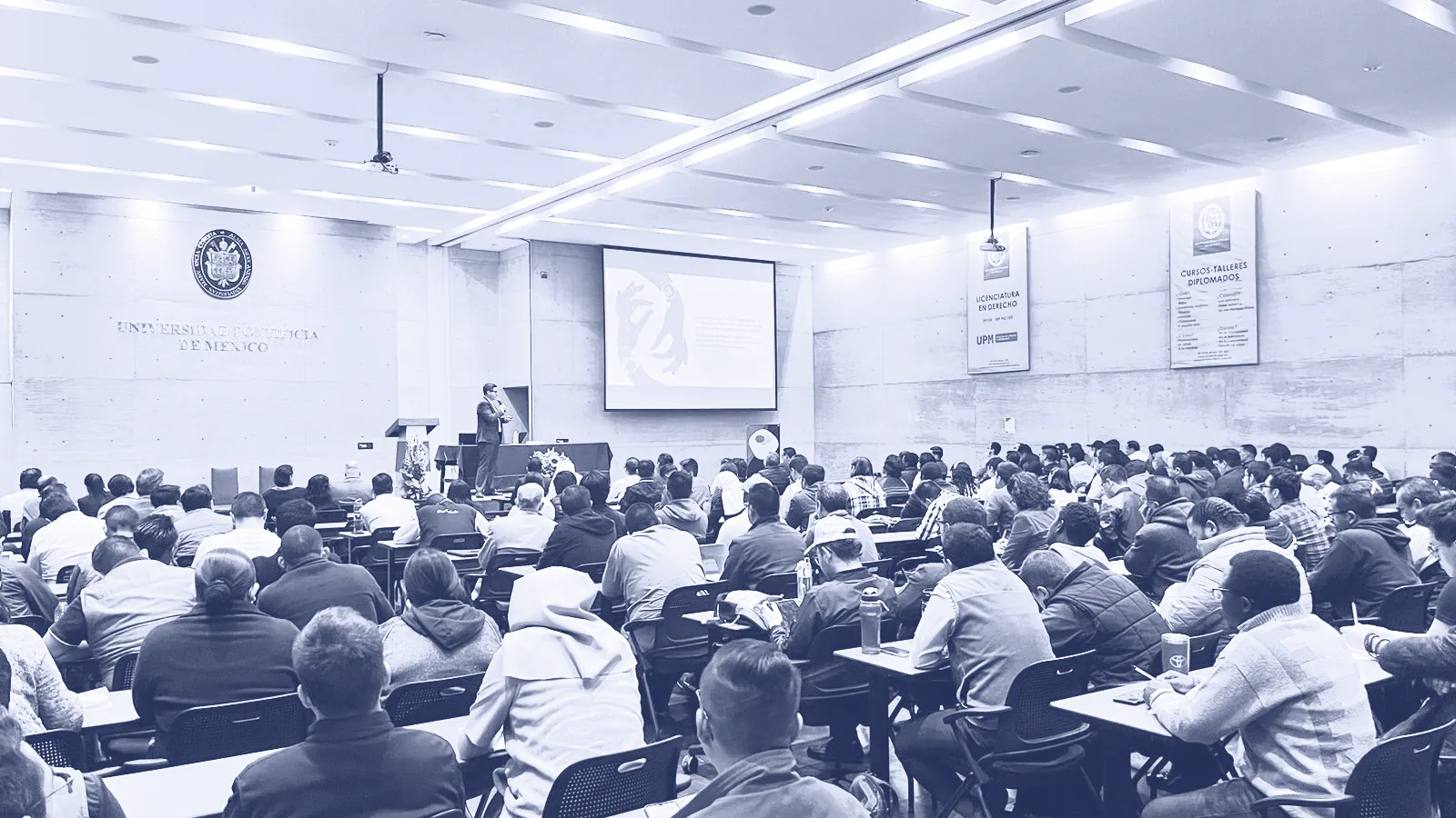 Amphithéâtre comble à l’Universidad Pontificia de México pendant une conférence d’Alex Servin